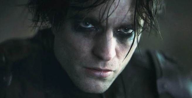 Robert Pattinson as Bruce Wayne in The Batman, shown having just removed the Batman mask and looking scruffy and goth