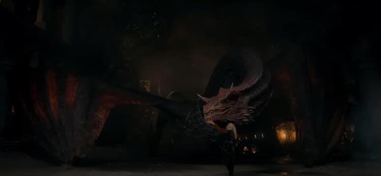 The red dragon Caraxes against a dark backdrop letting his rider, Daemon Targaryen, approach him.