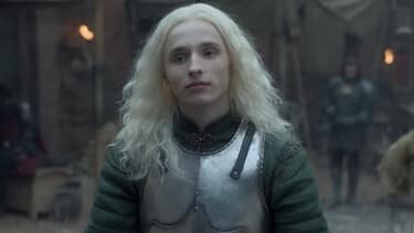 A closeup of Aegon Targaryen with his long silvery blond hair flowing loose, wearing an armor breastplate while training in the castle yard.