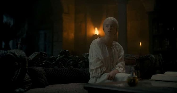 Rhaenyra sits in her night attire in her dimly lit bedroom. There is a decorative bottle on the table in front of her, and she's looking toward the door.