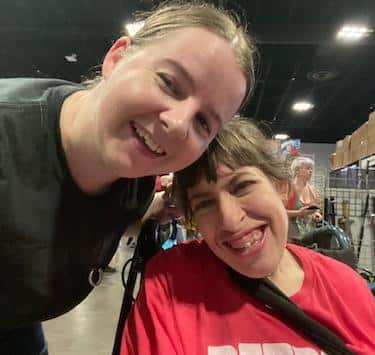 Selfie of Maria Kinnun and Shana Martin, both smiling, the convention vendors in the background.