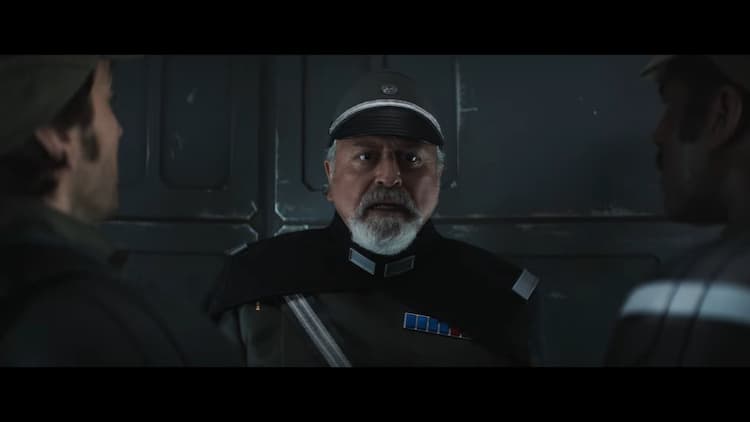 An Imperial officer is standing in the middle of a small group looking distressed. On either side of him we see the obscured backs Cassian and another rebel stand in Imperial uniform disguises.