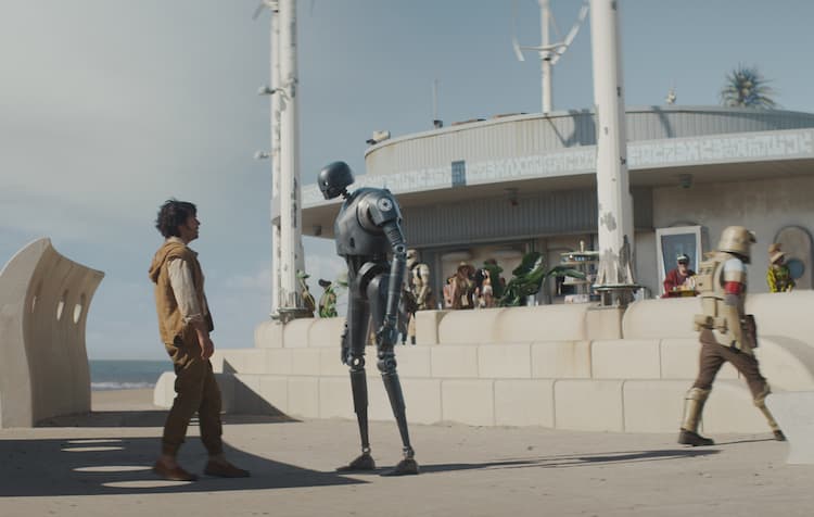 Cassian is looking up at an Imperial security droid with a coastal defender stormtrooper walking off to the right.
