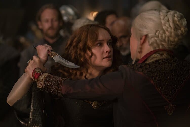 Alicent has wild eyes holding a dagger pointed at Rhaenyra, and Rhaenyra is grabbing Alicent's wrist to keep the dagger away.