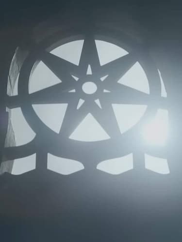 A seven-pointed star, the symbol of the Faith of the Seven, is part of a window frame in the Red Keep, the light shining in behind it.