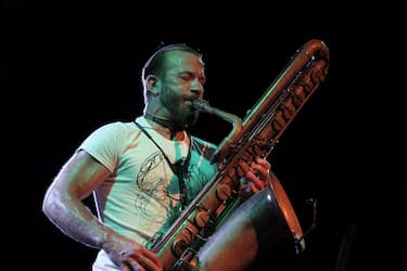 Colin Stetson playing a saxophone at a concert.