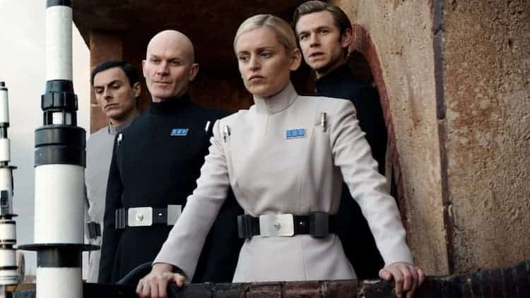 Dedra Meero and other Imperial officers stand on the balcony overlooking the funeral in the street below.