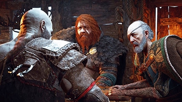 Thor, Odin, and Kratos sit in a small huddle in a ramshackle building talking.