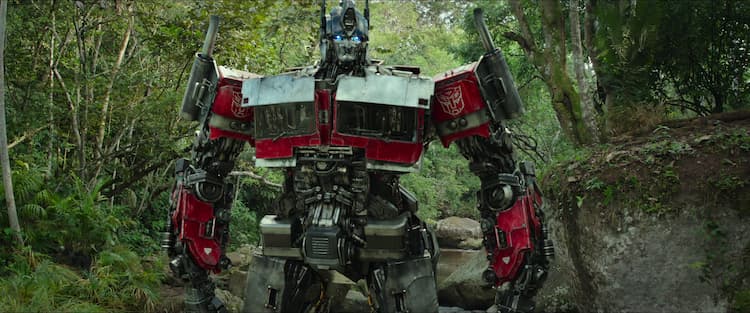 Optimus Prime stands in a forest.