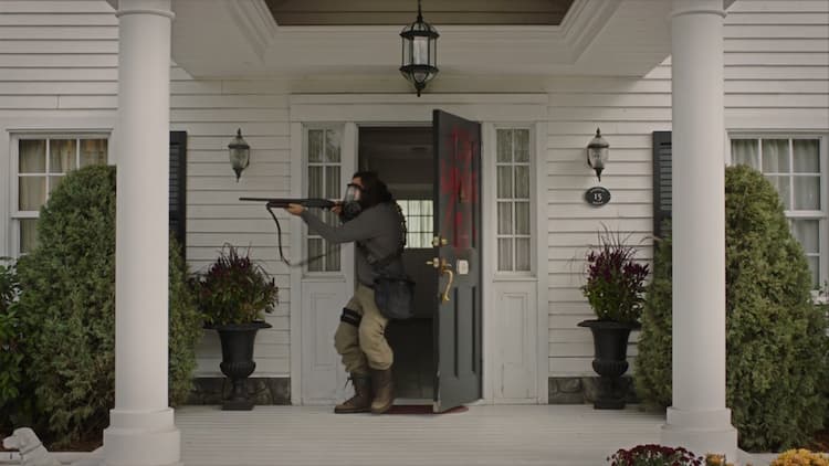 Bill gingerly exits his house, brandishing a shotgun and wearing a gas mask