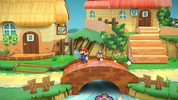 Paper Mario and Goombella are walking over a bridge. They are crossing a small river. Two buildings are in the background. One has a bed sign and the other has a flower sign.