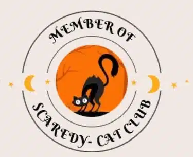 This image was made to represent a club patch or pin. It has two circles. The center circle has a black cat looking scared on an orange background. The outer circle says Member of The Scaredy-Cat Club in fancy black letters