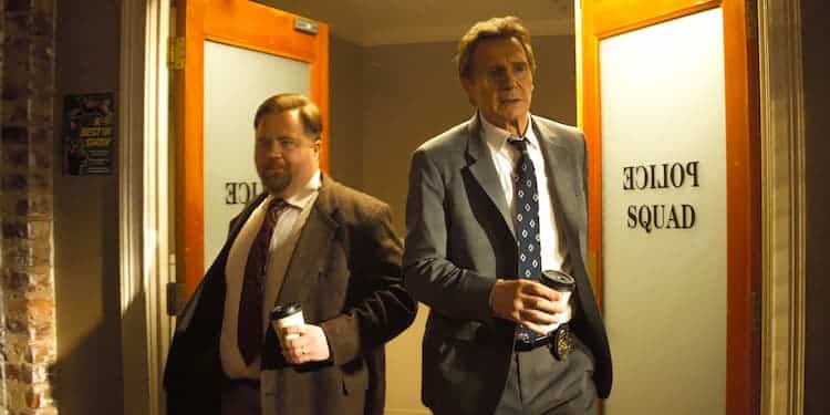 Ed and Frank are walking through the doors to the Police Squad office. They are both holding coffee cups. Ed is holding it in his left hand, and Frank is holding it in his right.